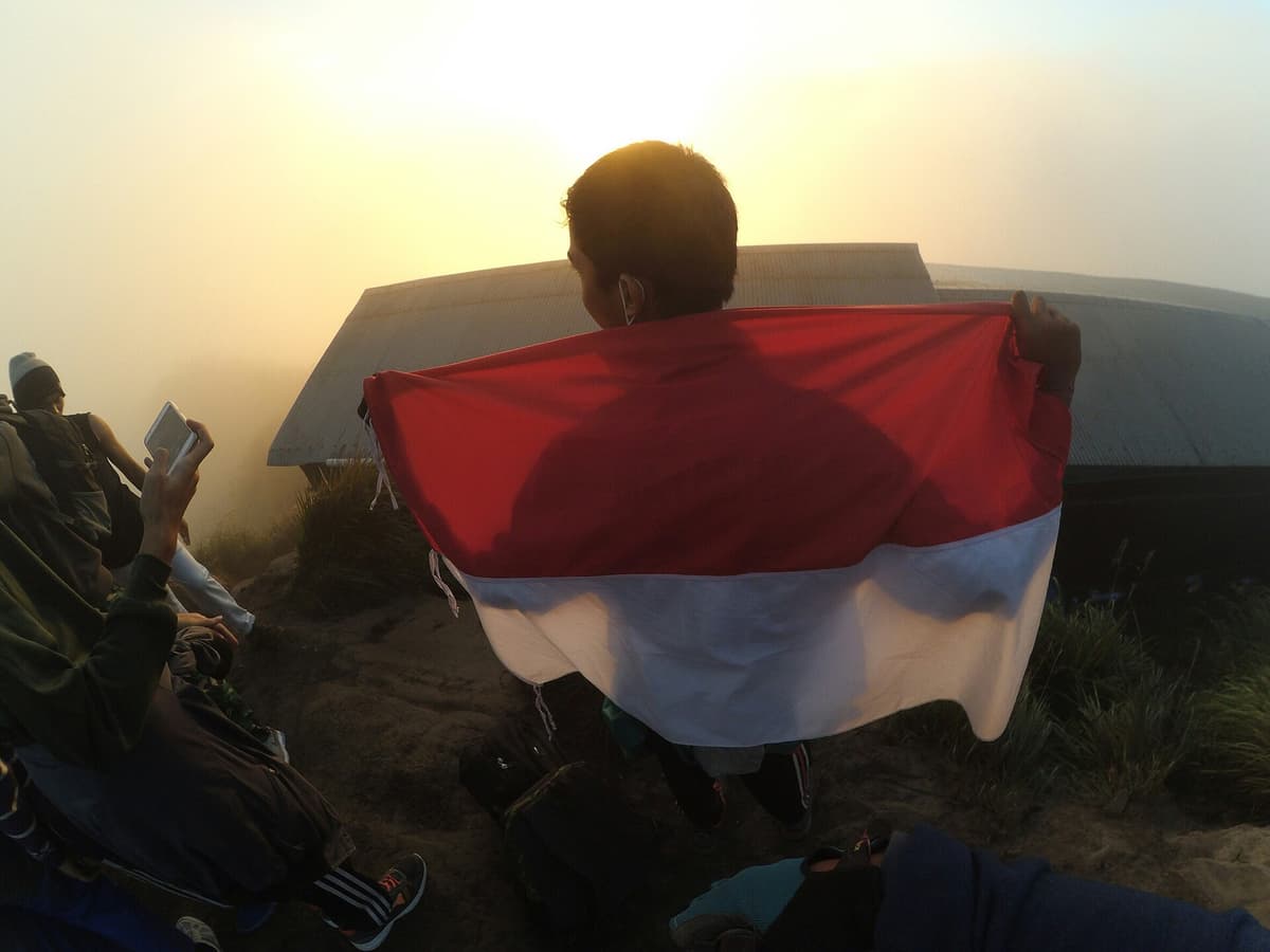 Trekking Mount Batur | Bali | Go Bali Visa Agency Indonesian flag on the summit of Mount Batur after a volcano trek in Bali